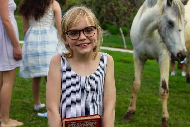 Kurzsichtigkeit bei Kindern - Mädchen mit Brille vor einem Pferd